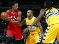 DeMar DeRozan, left, of the Toronto Raptors looks to make a play with the ball while being defended by Jameer Nelson, second from left, and Kennth Faried of the Denver Nuggets during NBA action Friday night in Denver. DeRozan had another big night with 30 points as the Raptors won 113-111 in overtime.