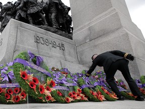 A Canadian Forces member adjusts a wreath after the Remembrance Day ceremony at the National War Memorial in Ottawa, November 11, 2011.