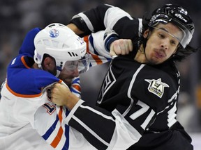 Patrick Maroon, left, of the Edmonton Oilers gets all tangled up with Jordan Nolan of the Los Angeles Kings during NHL action in Los Angeles on Thursday night. Despite a host of injuries, the Kings defeated the free-falling Oilers 4-2, snapping a four-game losing streak in the process.