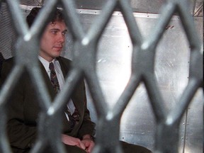 Paul Bernardo, who is scheduled for a day-parole hearing next March, is seen in the back of a police van wearing handcuffs and leg irons in a Nov. 3, 1995, file photo.