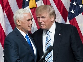 Donald Trump confers with Mike Pence during a rally in New York City July 16, 2016