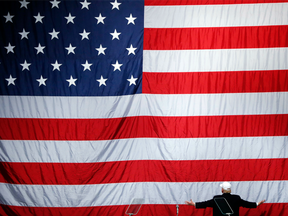 Donald Trump turns to a large U.S. flag during a campaign rally in Sterling Heights, Mich., on Sunday, Nov. 6, 2016.