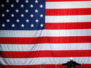 Donald Trump turns to a large U.S. flag during a campaign rally in Sterling Heights, Mich., on Sunday, Nov. 6, 2016. 