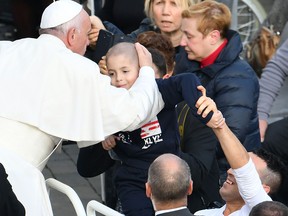 Pope Francis blesses a child from the popemobile after the celebration of a mass marking the end of the Jubilee of Mercy, on November 20, 2016 in Vatican.