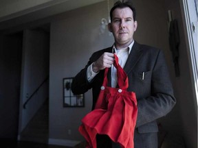 Thom Cholowski holds up a dress that is believed to be made from a World War Two era, Nazi flag in his home in Saskatoon, Saskatchewan on Saturday, November.