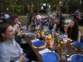 In this Oct. 2, 2016, file photo, diners smoke marijuana as they eat dishes prepared by chefs during an evening of pairings of fine food and craft marijuana strains served to invited guests dining at Planet Bluegrass, an outdoor venue in Lyons, Colo.