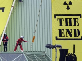 In this March 5, 2014 file picture Greenpeace activists hang banners saying  'The End,' at a building of the Nuclear power plant Beznau near Doettingen, Switzerland