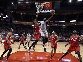 Toronto Raptors defenders encircle Houston Rockets guard James Harden as he goes up for a layup on Nov. 23.