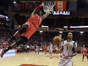 Toronto Raptors forward DeMarre Carroll hangs from the rim after a dunk against the Houston Rockets on Nov. 23.