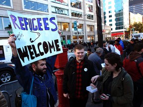 Members of the organization Wear Safety distribute safety pins as a sign of solidarity against intolerance during a rally against US President-elect Donald Trump in Union Square on November 12, 2016, in New York. Americans spilled into the streets Saturday for a new day of protests against Donald Trump, even as the president-elect appeared to back away from the fiery rhetoric that propelled him to the White House.