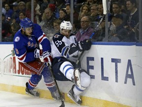 Brady Skjei, left, of the New York Rangers has a board meeting with Mark Scheifele of the Winnipeg Jets during NHL action Sunday in New York. The Rangers had things their way in a 5-2 victory, their fifth straight win.