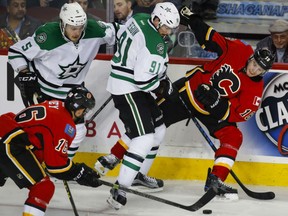 Tyler Seguin battles with Calgary Flames' Matt Stajan along the boards during NHL action Thursday night in Calgary. The Stars were 4-2 winners, handing Calgary its fifth loss over their last six games.