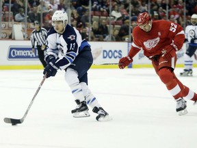 Brandon Tanev, left, of the Winnipeg Jets moves the puck up ice as Detroit Red Wings' defenceman Jonathan Ericsson tries to catch up during NHL action Friday night in Detroit. Tanev had his first two goals of his NHL career in leading the Jets to a 5-3 victory.