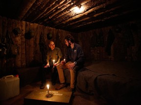 Bosnian Arian Kurbasic, left, the owner of the War Hostel in Sarajevo talks to one of his guests, Andrew Burns from the U.S., in the replica of an underground wood bunker built in the hostel basement.