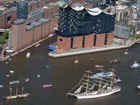 Tall ships pass by the Elbphilharmonie building in Hamburg, northern Germany.