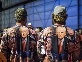 Attendees wear t-shirts featuring Donald Trump, 2016 Republican presidential nominee, during a campaign rally in Moon Township, Pennsylvania, U.S., on Sunday, Nov. 6, 2016.