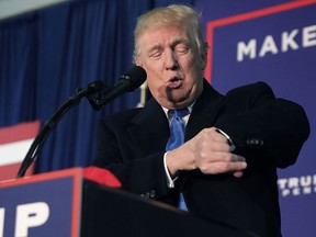 Republican presidential nominee Donald Trump checks his watch and announces it is a "midnight rally," during a campaign stop in Leesburg, Va., Nov. 7, 2016.