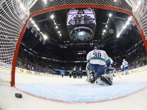 Vancouver Canucks goaltender Ryan Miller watches New York Islanders players celebrate a goal on Nov. 7.