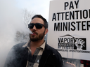 A man vapes at a rally in support of e-cigarettes in front of the Ontario legislature