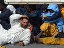 This file picture taken on April 20, 2015 shows a man now identified as Tunisian national Mohammed Ali Malek (FOREGROUND), one of the survivors and understood to be the captain of the boat that overturned off the coasts of Libya, sits on board the Italian Coast Guard vessel Bruno Gregoretti at Boiler Wharf, Senglea in Malta.