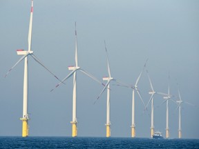 This file photo taken on November 04, 2015 shows a service vessel passing by wind turbines of the German offshore wind farm "Amrum Bank West" owned by German energy company E.ON near the Heligoland archipelago on the North Sea, on November 4, 2015.