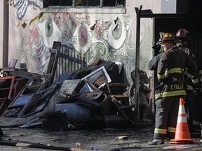 Firefighters work at the scene following an overnight fire in Oakland