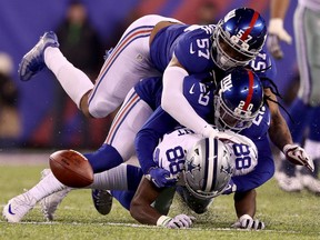 Dez Bryant of the Dallas Cowboys loses the ball while being tackled by a couple of New York Giants in Sunday's NFL Game at the Meadowlands in East Rutherford, N.J. The Giants posted a 10-7 win over the Cowboys, snapping their 11-game winning streak.