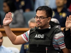 Kerwin Espinosa, son of the late mayor Rolando Espinosa, takes an oath during the Senate drug hearing at the Senate building in Manila on November 23, 2016.