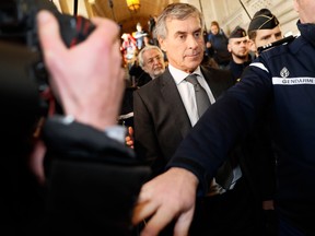 Gendarmes escort French former budget minister Jerome Cahuzac (C) as he leave the Paris courthouse following his tax fraud and money laundering trial's verdict on December 8, 2016.