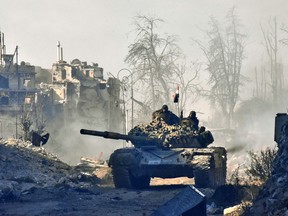 Syrian pro-government forces manoeuver a tank in the newly retaken area of Sahat al-Melh and Qasr al-Adly in Aleppo's Old City on December 8 — the government's gains were supported by Russia, and Western leaders are condemning the nation's role in spurring the humanitarian crisis in the country.
