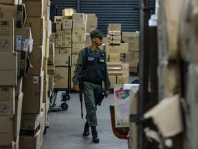 A member of the Venezuelan national guard walks between boxes full of confiscated toys in a warehouse in Caracas on December 9, 2016