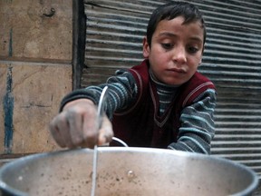 A Syrian child cooks in the street in a rebel-held area of Aleppo, on December 13, 2016, during an operation by Syrian government forces to retake the embattled city.