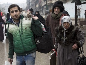 Syrians leave a rebel-held area of Aleppo towards the government-held side on December 13, during an operation by Syrian government forces to retake the embattled city and evacuate civilians — an effort that appears to have broken down.