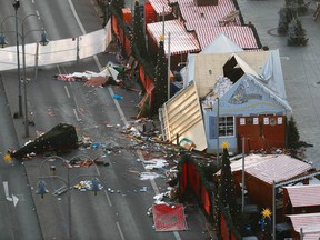 Police patrol inside the Christmas market area and past the destroyed booths after an attack with a truck in front of the Kaiser-Wilhelm-Gedaechtniskirche in Berlin on December 21, 2016