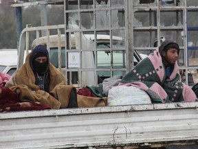 Syrians evacuated from Aleppo ride in the back of a pick up truck as it drives through a rebel-held territory near Rashidin, west of the embattled city, on Thursday.