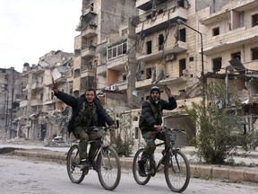 Syrian regime forces flash the "V" for victory sign in the former rebel-held Sukkari district in the northern city of Aleppo on December 23, 2016