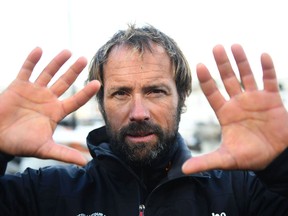 French skipper Thomas Coville holds up his hands following his arrival in the port of Brest, western France, on December 26, 2016, after beating the record in solo non-stop round the world sailing.