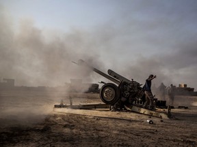 An Iraqi soldier fires a canon towards the ISIL-held village of Ganus, south of Mosul, Iraq, Sunday, Dec. 11, 2016