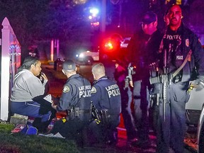 Police stand by a distraught woman at the scene where a Tacoma Police officer was shot while responding to a domestic call in East Tacoma, Wash., Wednesday, Nov. 30, 2016.