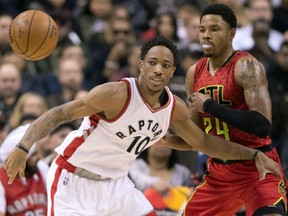 Raptors guard DeMar DeRozan battles for a loose ball with the Atlanta Hawks' Kent Bazemore during first-half action in Toronto on Saturday night.