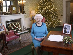 In this photo released early Sunday Dec. 25, 2016, Britain's Queen Elizabeth II poses for a photo, sitting at a desk in the Regency Room of Buckingham Palace in London, after recording her traditional Christmas Day broadcast to the Commonwealth. Queen Elizabeth prerecords her traditional Christmas Day festive speech to be broadcast to the British Commonwealth nations on Christmas Day.