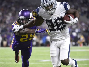 Dallas Cowboys' receiver Dez Bryant fends off the tackle attempt by Minnesota Vikings' Xavier Rhodes for what proved to be the game-winning touchdown in the Thursday night NFL game in Minnesota.  The Cowboys won a franchise-record 11th straight game, 17-15.