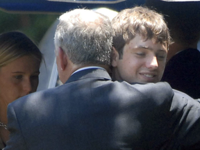 Burke Ramsey hugs his father, John, at the grave of his murdered sister JonBenet Ramsey in 2006.