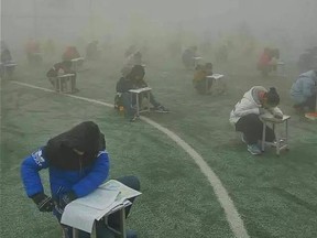 Photos shared widely on Chinese social media showed students in Henan province hunched over their desks taking an exam while shrouded in a grey haze.
