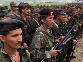 In this April 28, 2000, file photo, Revolutionary Armed Forces of Colombia, FARC, rebels stand in formation during a practice ceremony for the Boliviarian Movement, a new clandestine political party for the rebels, outside of San Vicente del Caguan in the FARC controlled zone of Colombia.
