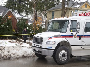 A London police officer leaves 56 Duchess Monday with a door ram as police investigate the home where Samuel Maloney died after a confrontation with police Friday morning, when he shot at an officer with a crossbow in London, Ont.