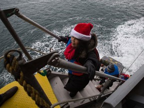 Volunteers from the Filipino community walk the gangway to board the stranded container ship Hanjin Scarlet near Saturna Island, British Columbia on December 20.
