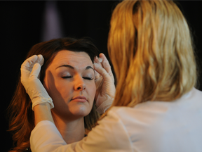 Dr. Christine Malcolm injects Botox into dermatology nurse Jennifer Gerein at the Grande Prairie Woman's Show in Grande Prairie, Alberta.