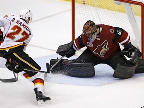 Doug Hamilton of the Calgary Flames puts the deke on Arizona Coyotes' goaltender Mike Smith to score the game-winning goal in overtime in a 2-1 victory over the Arizona Coyotes Thursday in Glendale , Az. The victory made it five straight for the Flames.