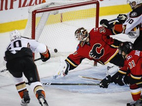 Antoine Vermette, left, of the Anaheim Ducks, redirects a pass into the goal past Calgary Flames' goaltender Chad Johnson during NHL action Thursday in Calgary. The Ducks were 3-1 winners.